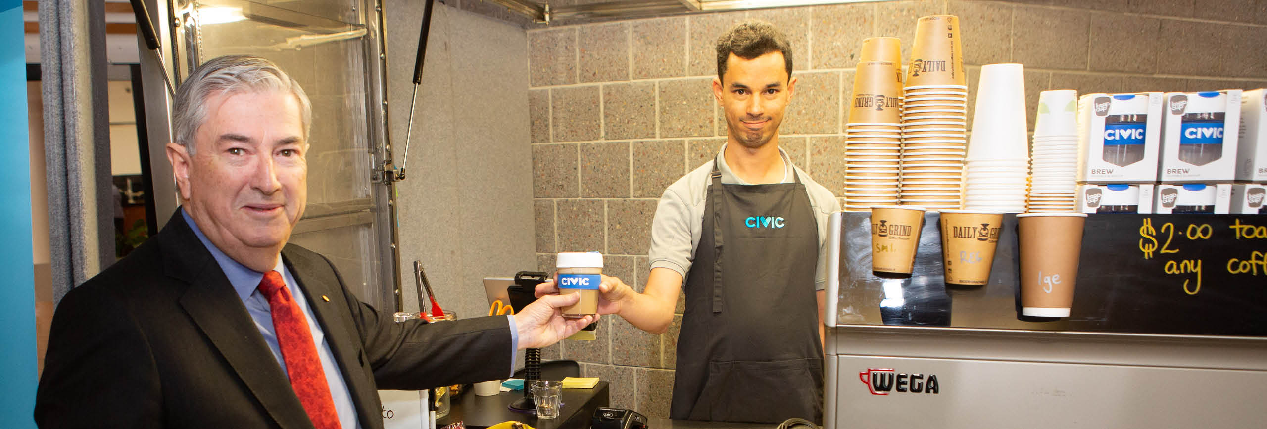 Penrith Mayor Ross Fowler receives his coffee from Martin at the Civic Disability Services coffee cart within Penrith Civic Centre