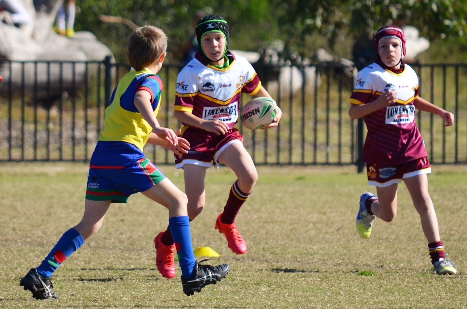 Three boys playing rugby