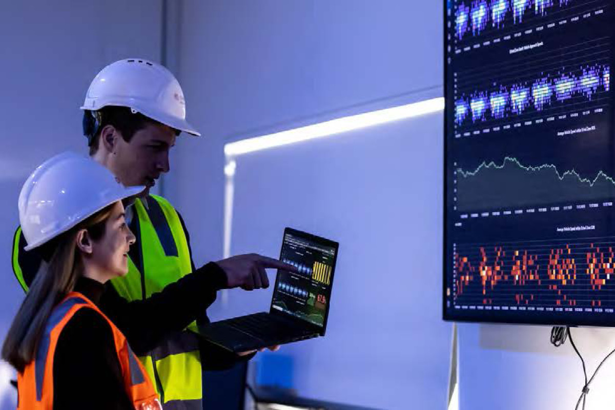 Manufacturing workers using laptop and software program.