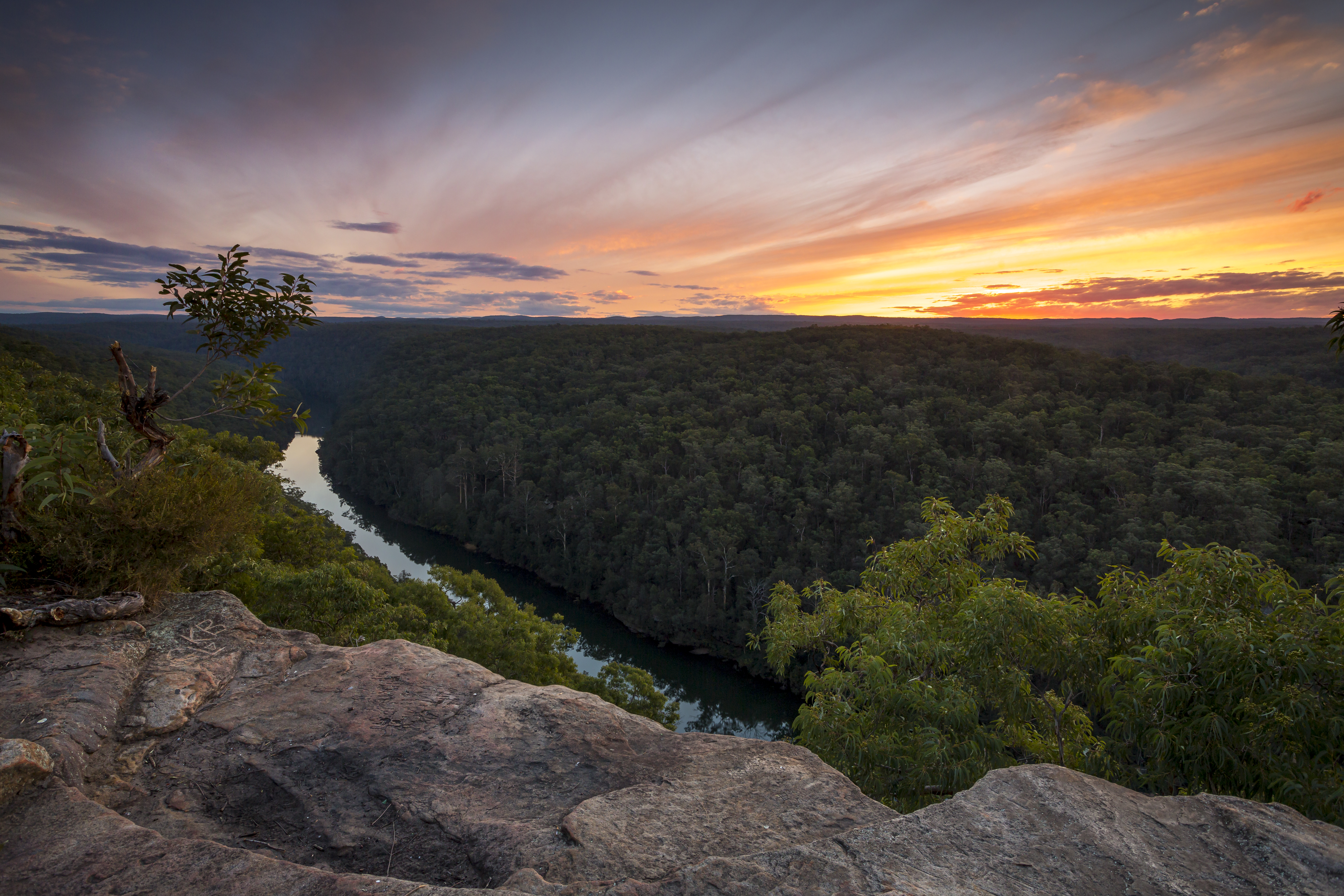 rock ledge with view of river and sunrise