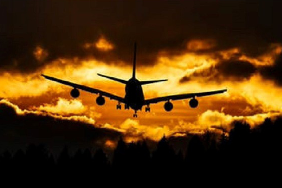 Airplane silhouette against sunset