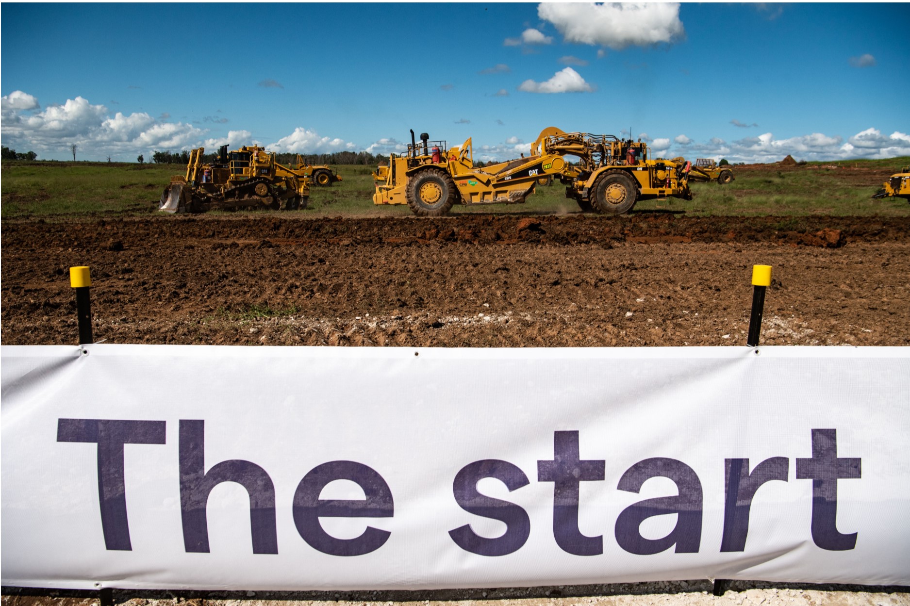 sign that says the start with construction vehicles behind