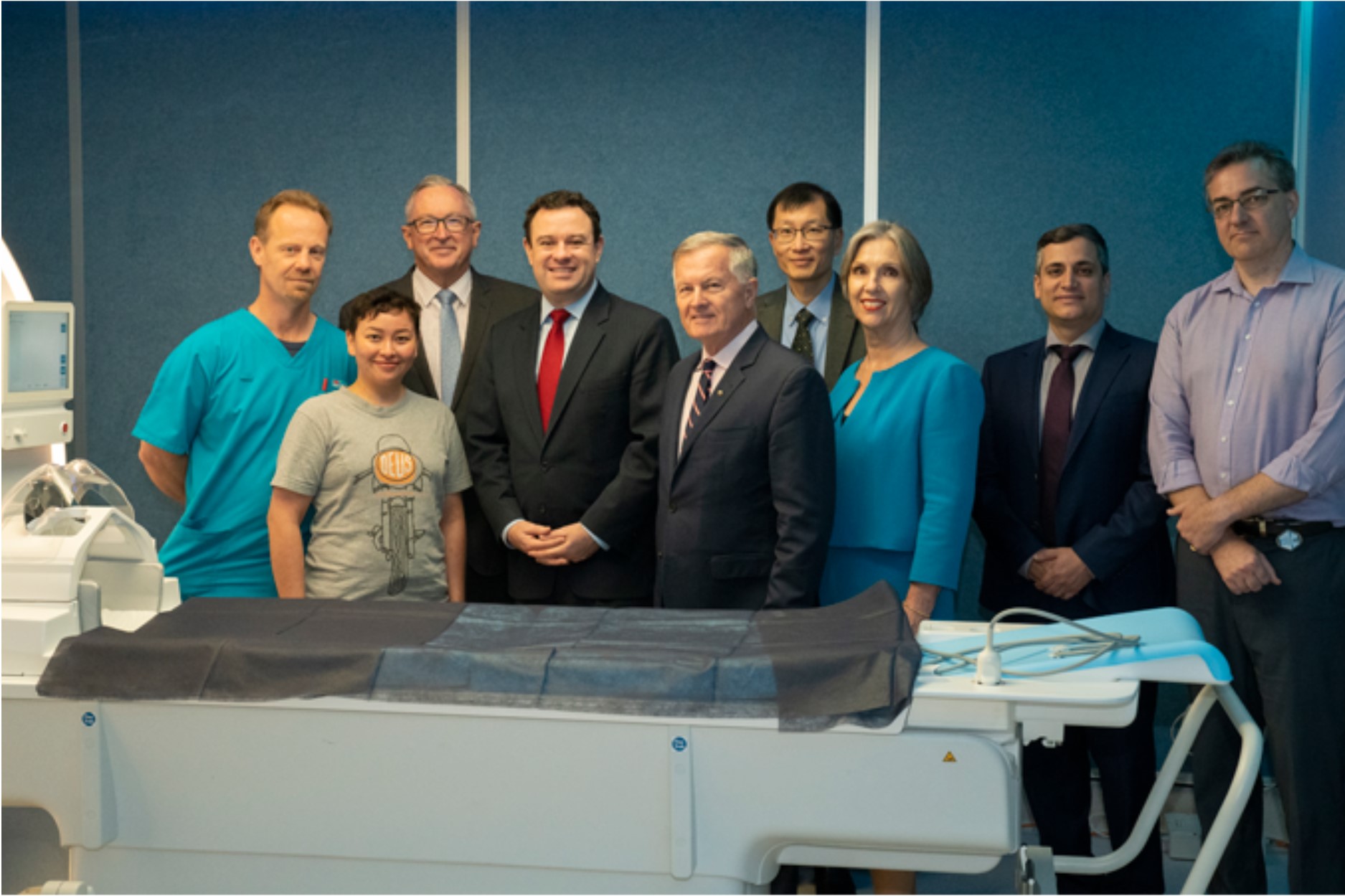 group of people standing next to an MRI machine