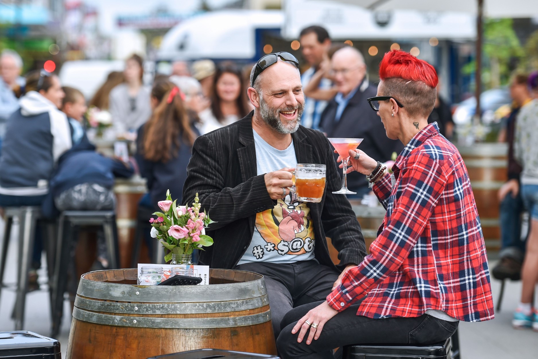 two people enjoying a drink amongst a crowd of people