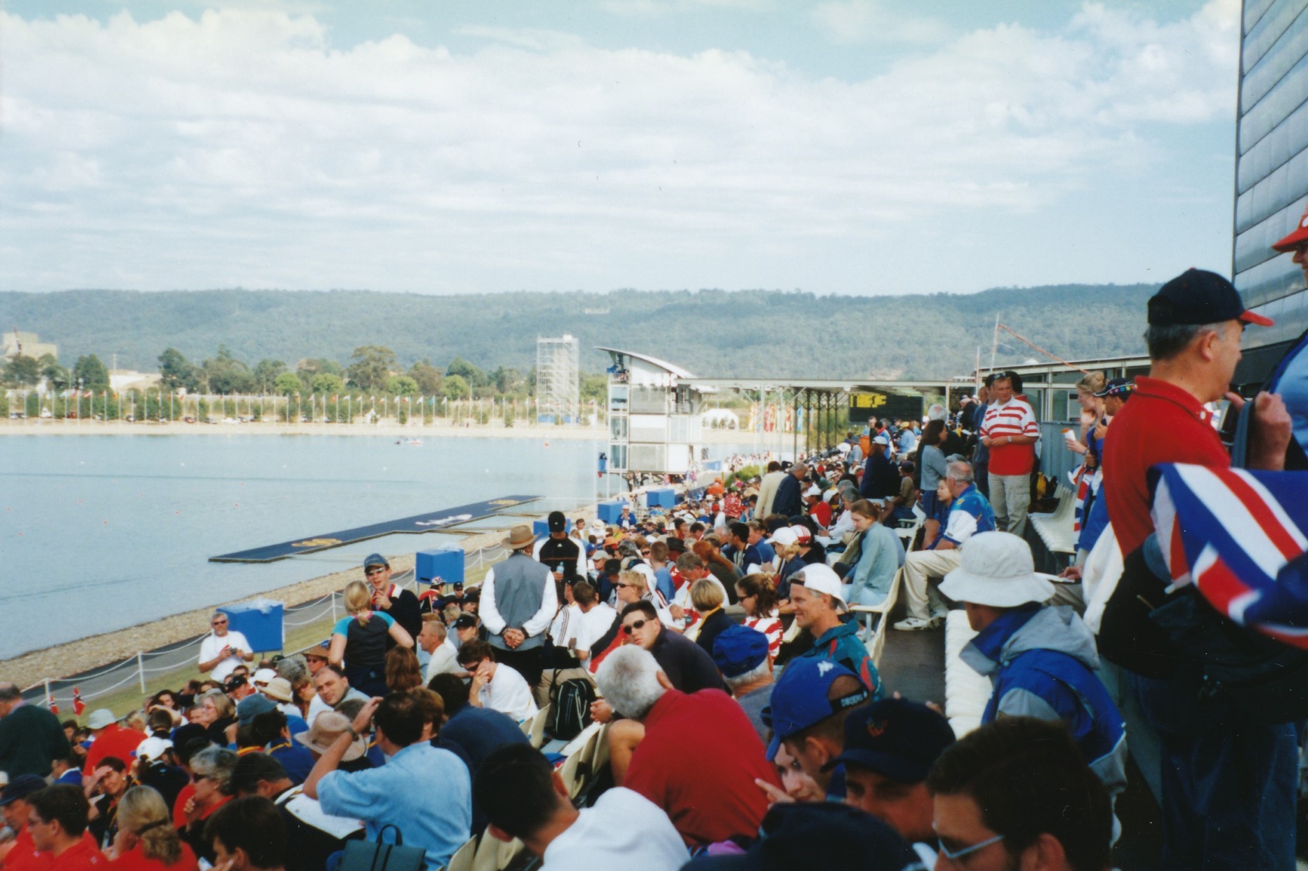 large crowd watches rowing on lake