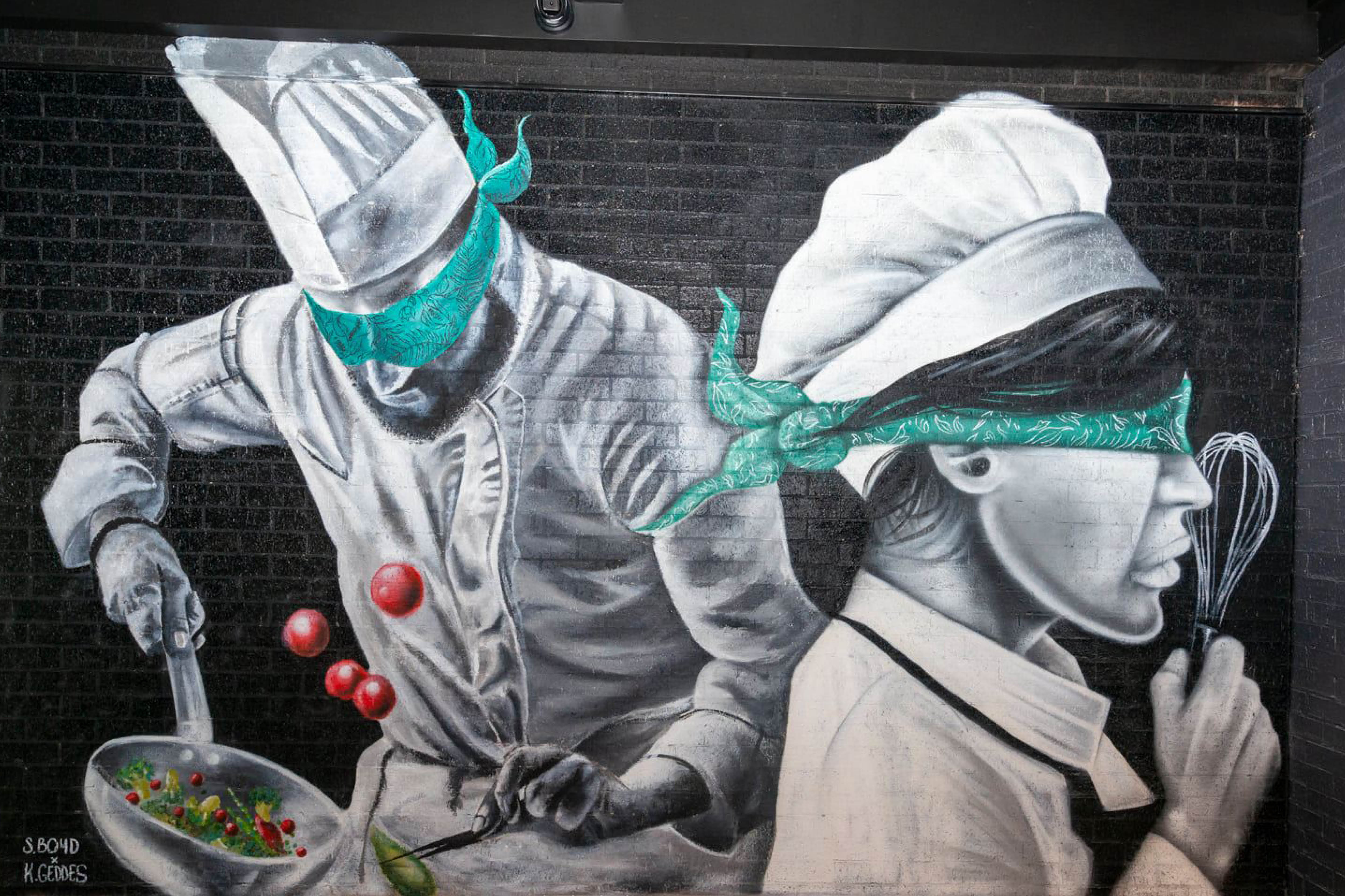 painted mural on wall of two chefs with blindfolds
