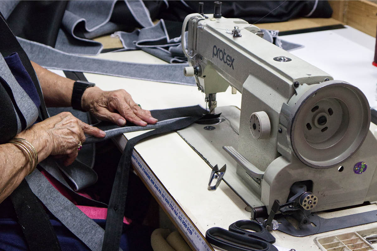 woman feeding fabric into a sewing machine