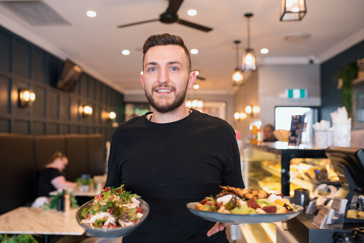 man holding food in cafe