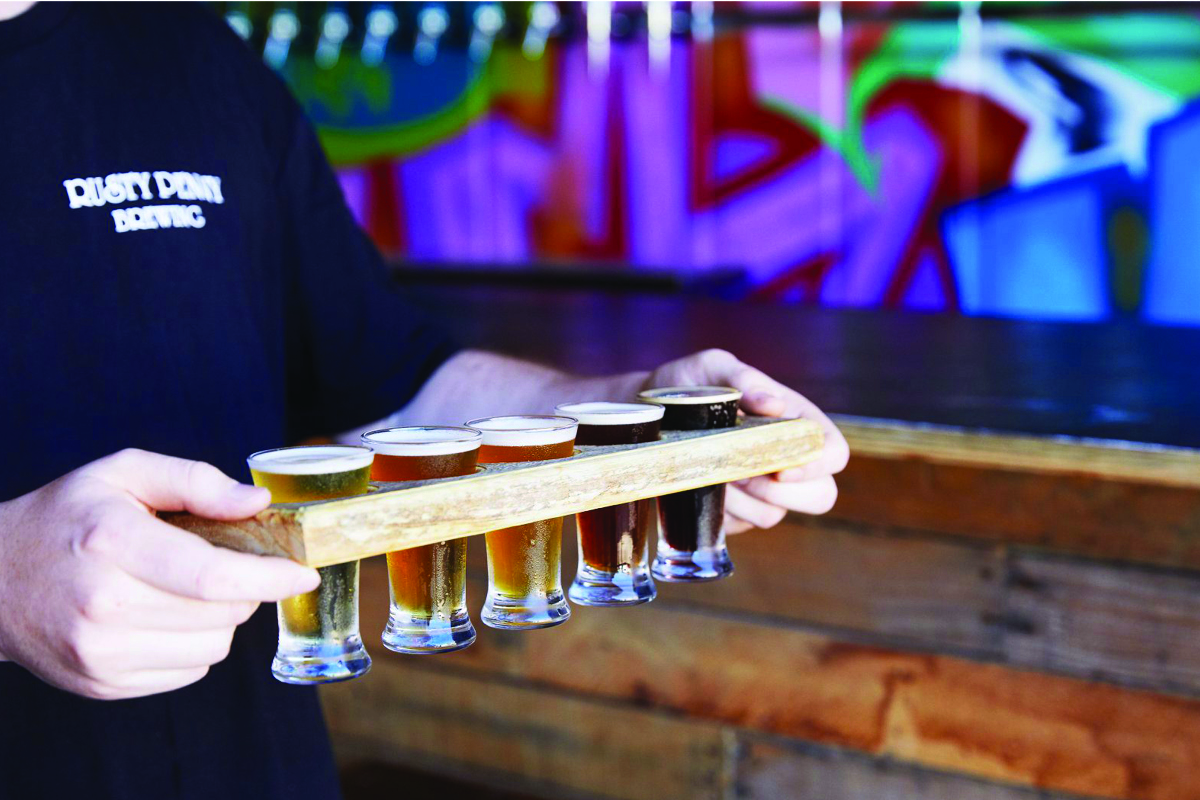 man holding tray of beers