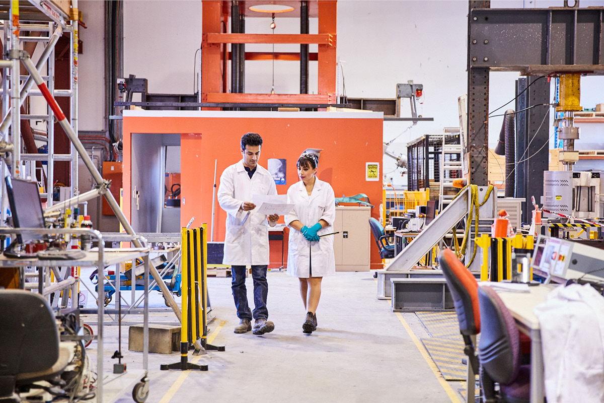 Man and woman walking through engineering facility