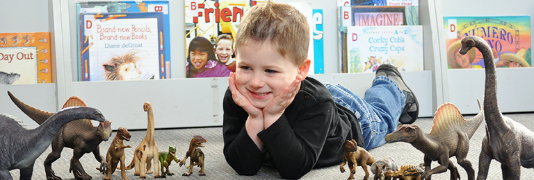A boy using dinosaurs at Penrith Library's toy library