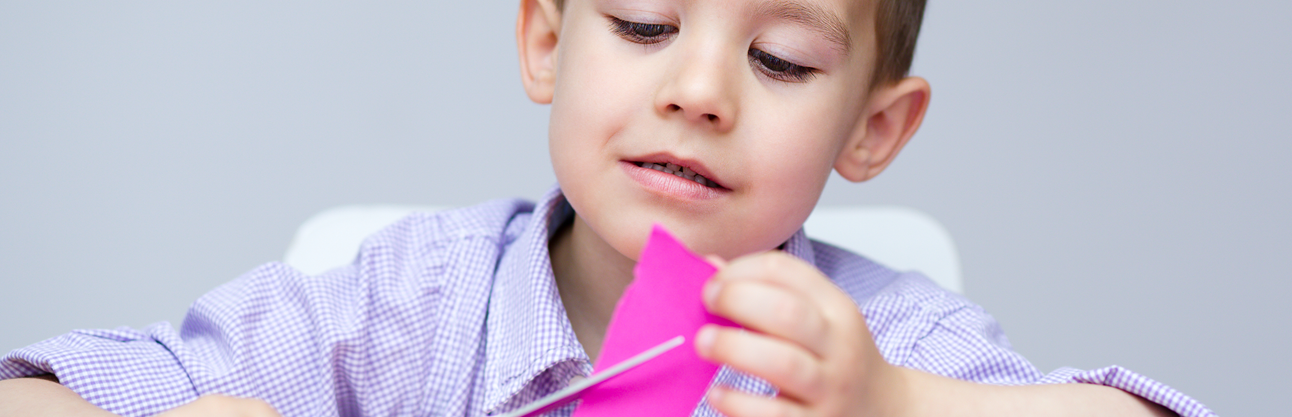 A child folding a piece of paper.