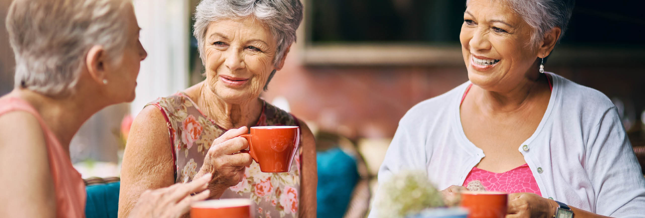 Women sitting around a table drinking coffee.