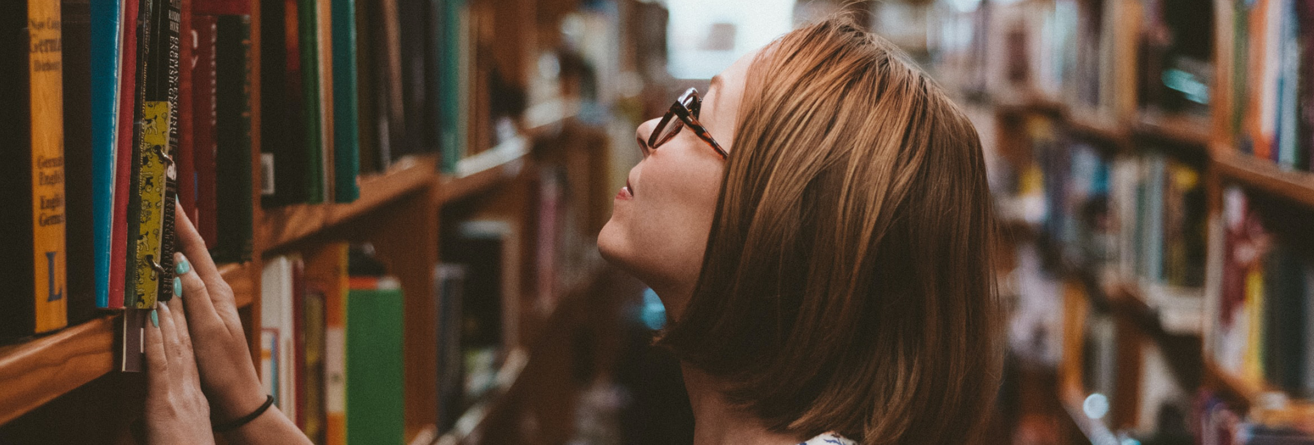 Woman looking at bookshelf.