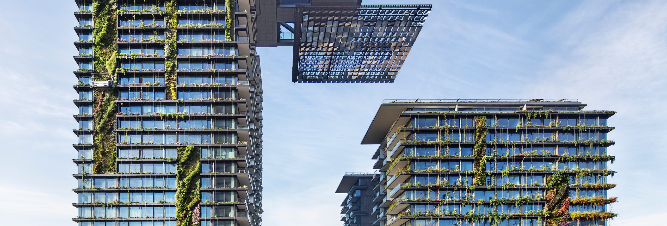 Apartment building with living green walls and solar panels